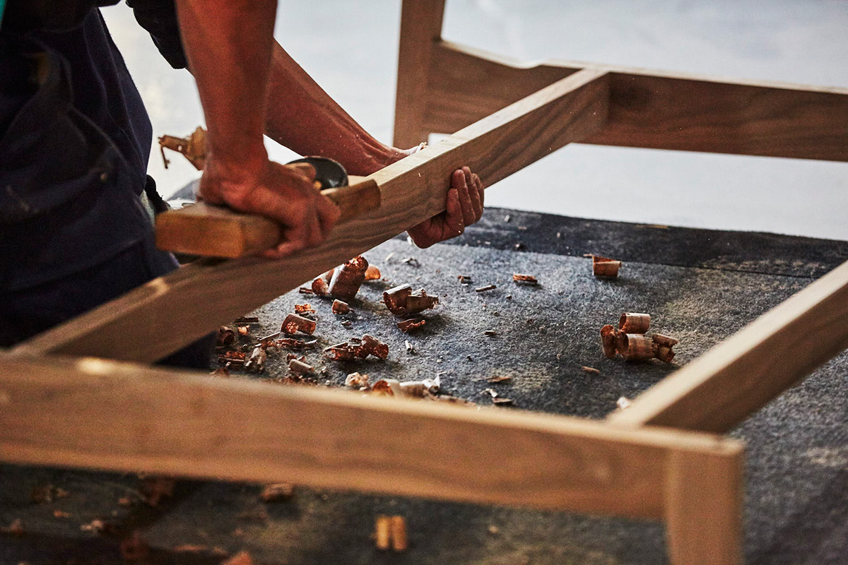職人が手作業で家具を仕上げる様子